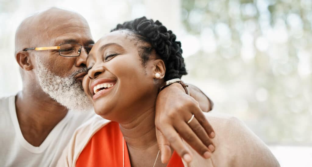 mature MI couple with hearing loss smiling and embracing